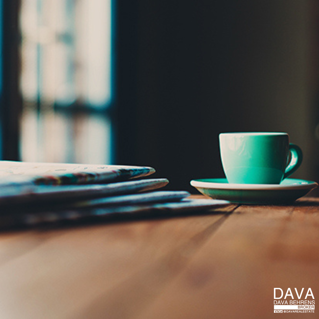 Teal coffee cup and stack of papers.