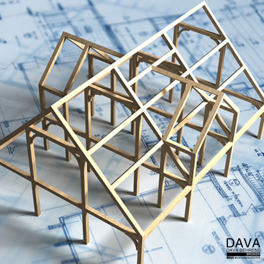 Model timber frame house on blueprints.