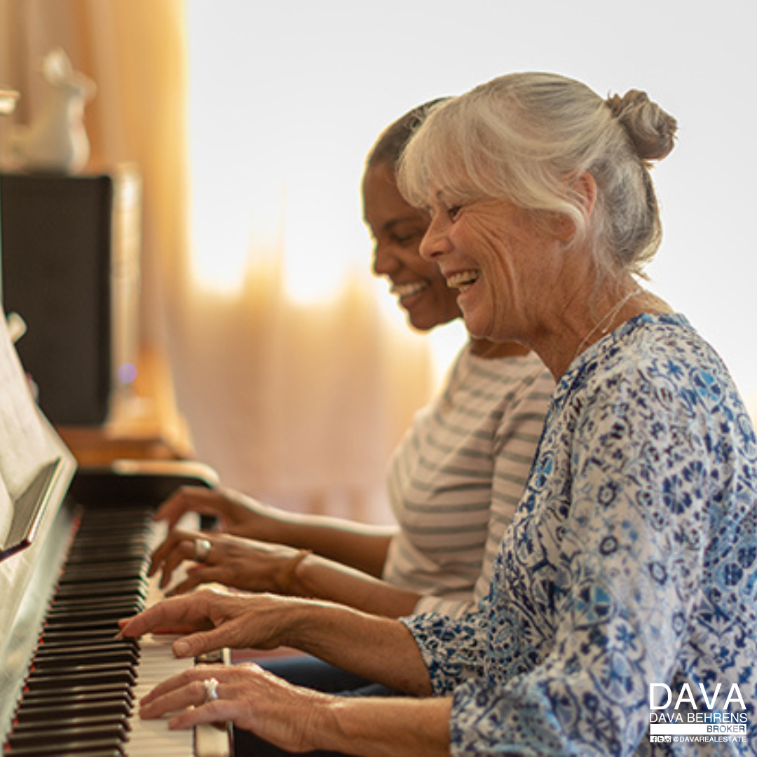 Two women playing piano together.