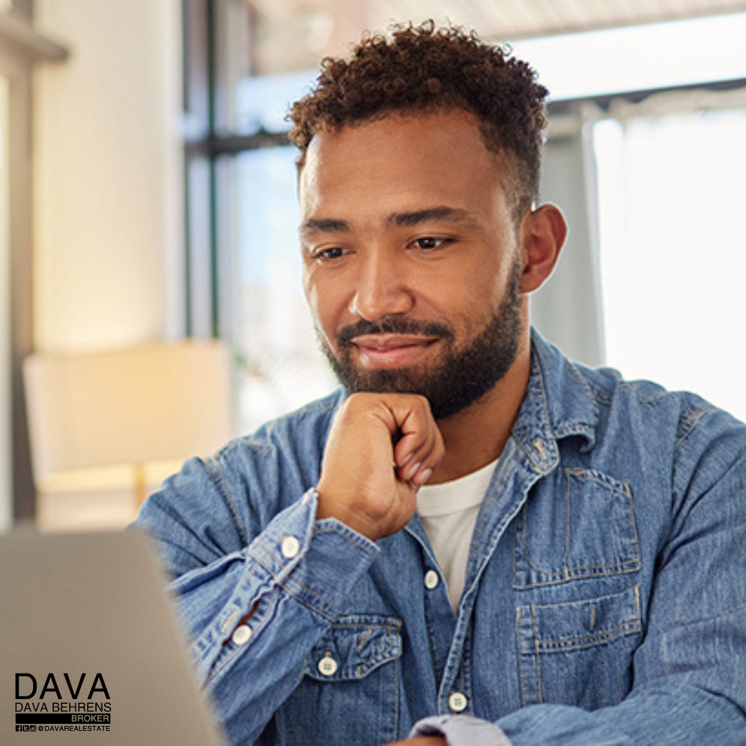 Man in denim shirt using laptop.