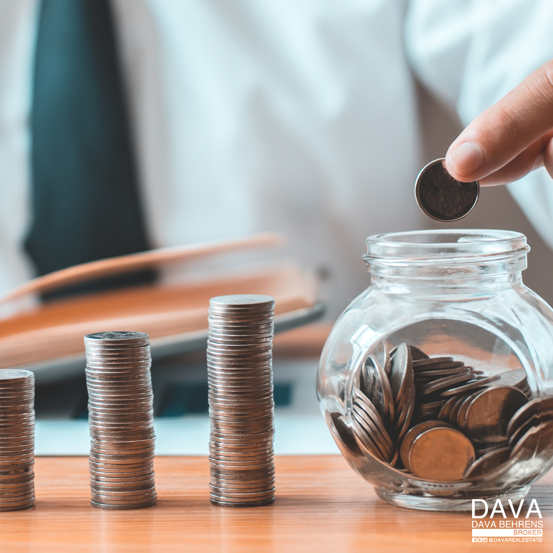 Person saving coins in glass jar.