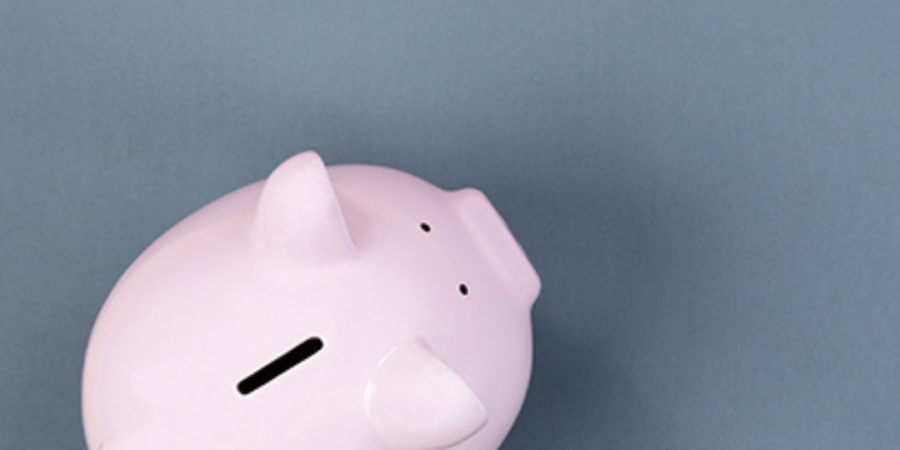 Pink piggy bank on blue background.