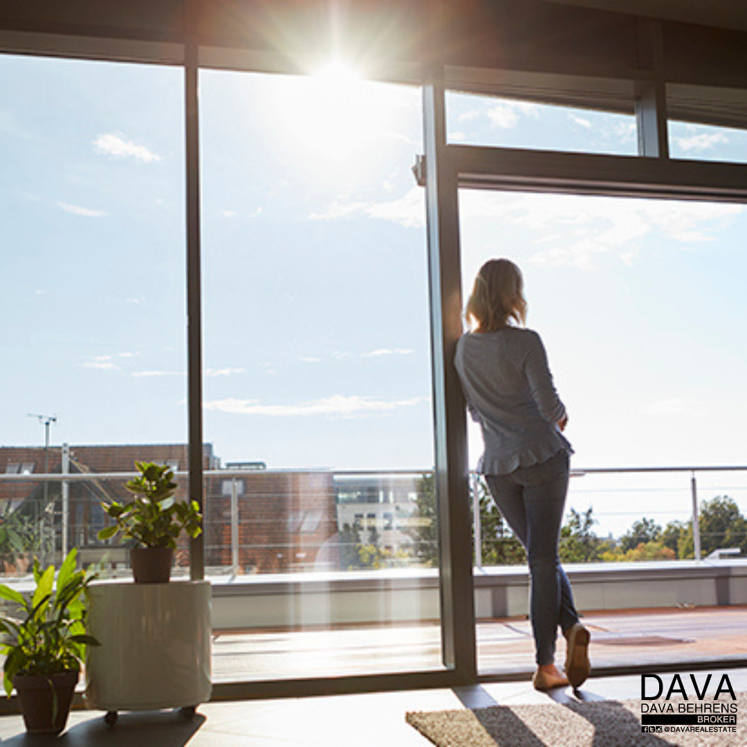 Woman looking out sunny window.