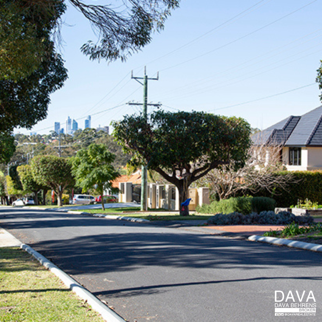 Suburban street scene with houses and trees.