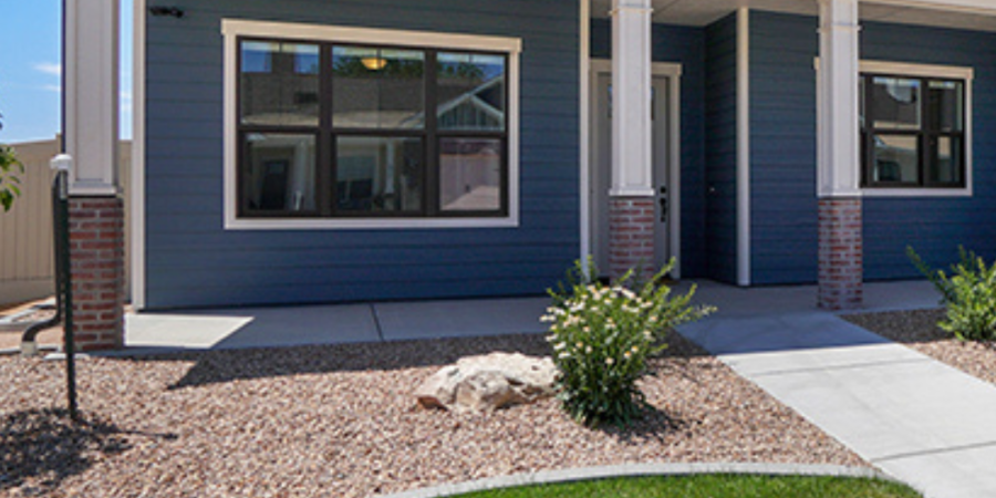 Blue house with porch and landscaping.