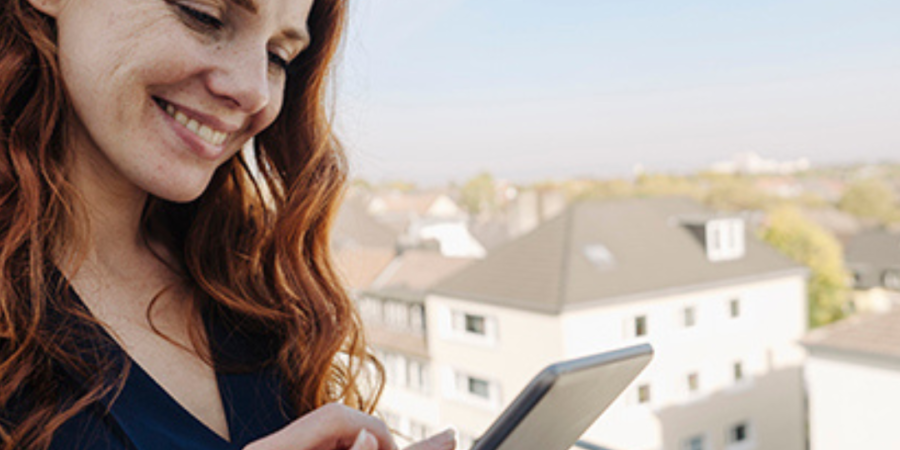 Woman using tablet, city view.