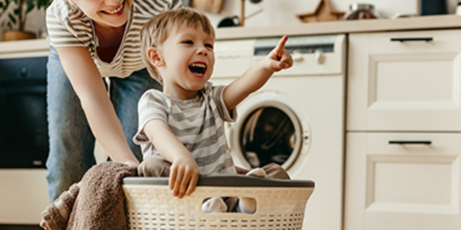 Mom and toddler in laundry basket.