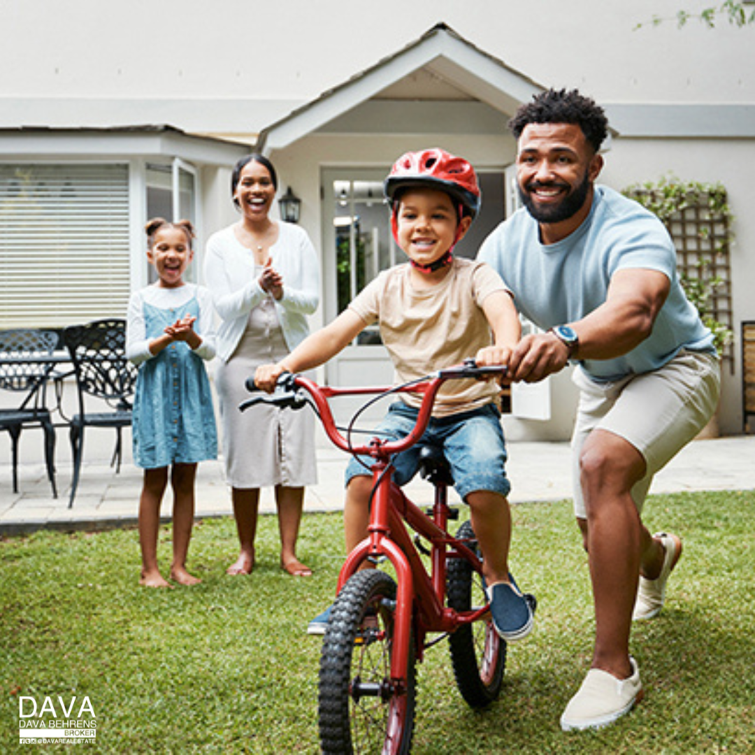 Family teaches child to ride bike.