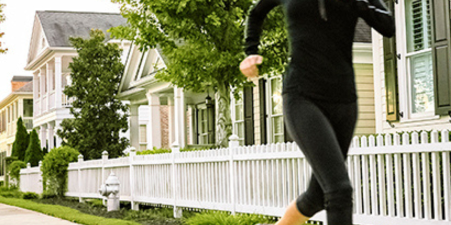 Woman jogging in residential neighborhood.