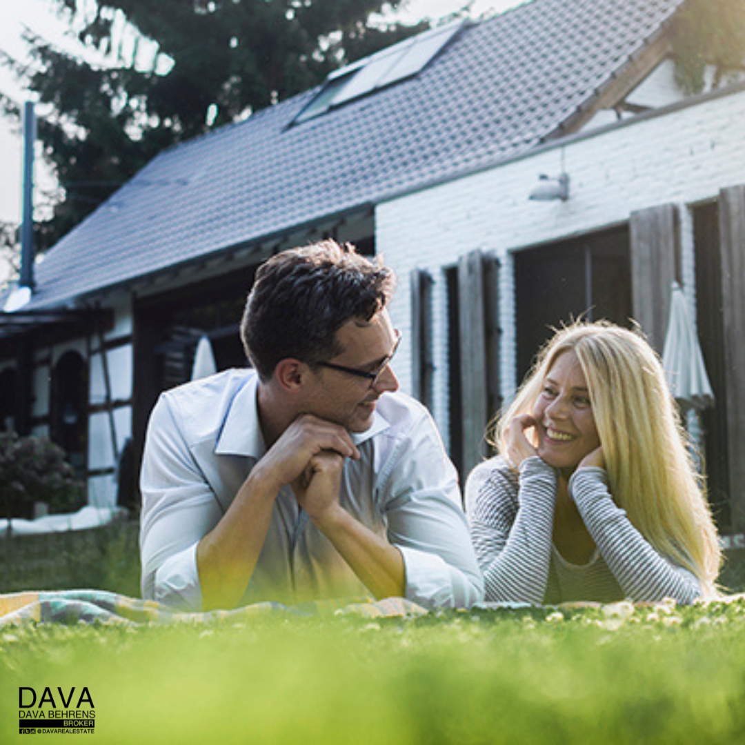 Couple relaxing on lawn, new home.