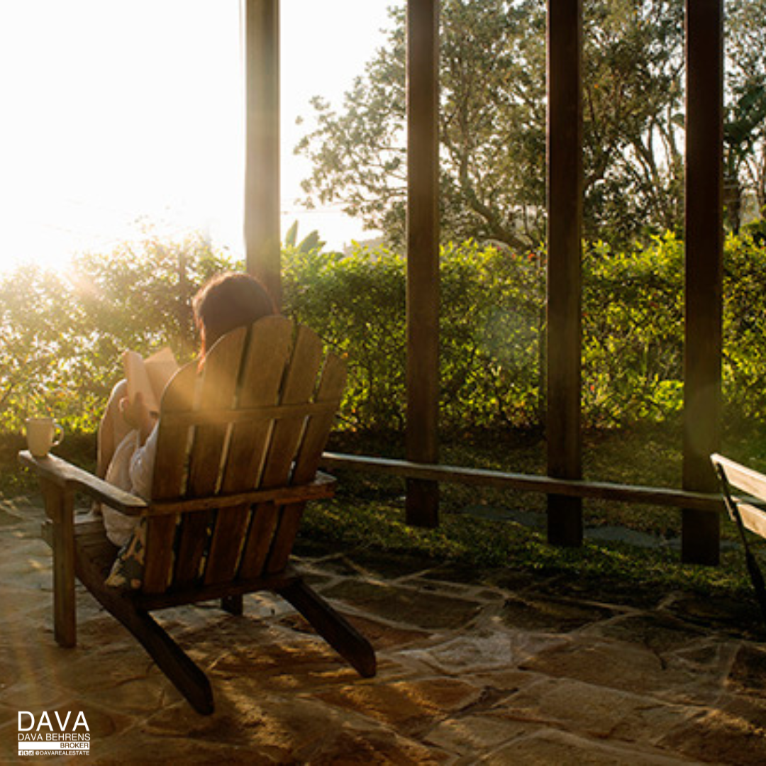 Woman reading on porch at sunset.