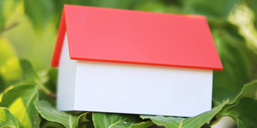 Small house model in green foliage.