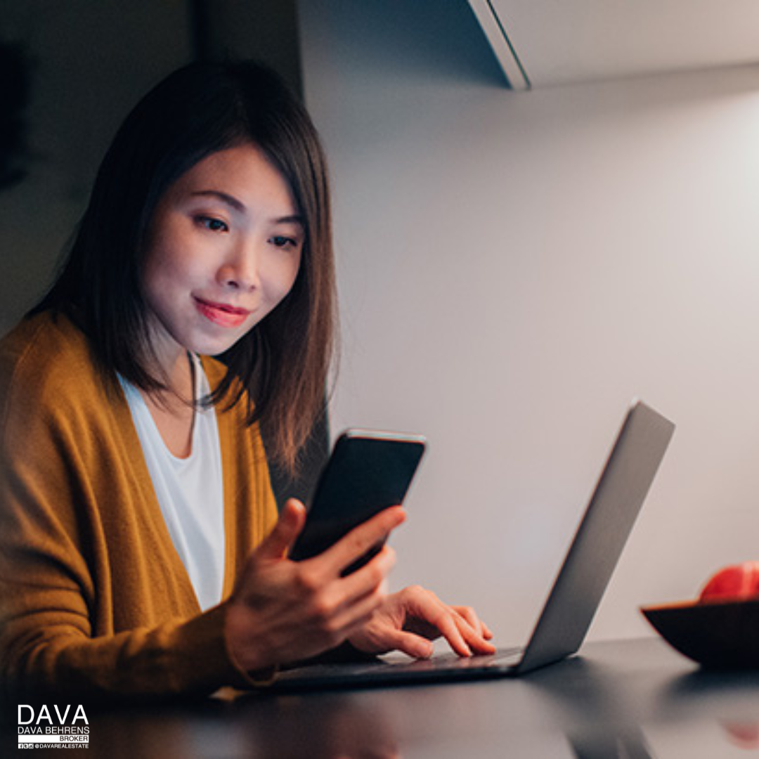 Woman using phone and laptop at night.