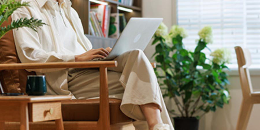 Man working on laptop in armchair.