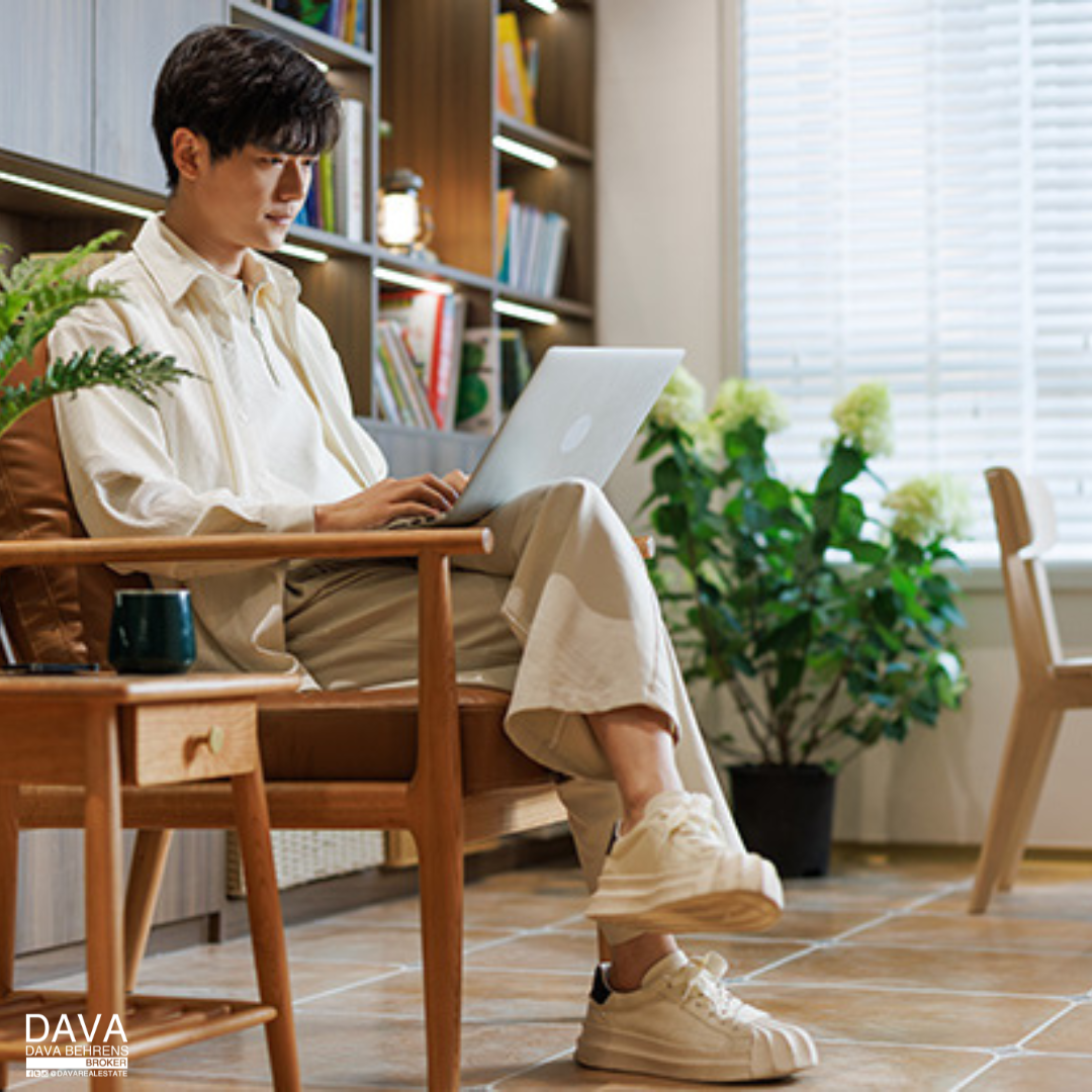 Man working on laptop in armchair.