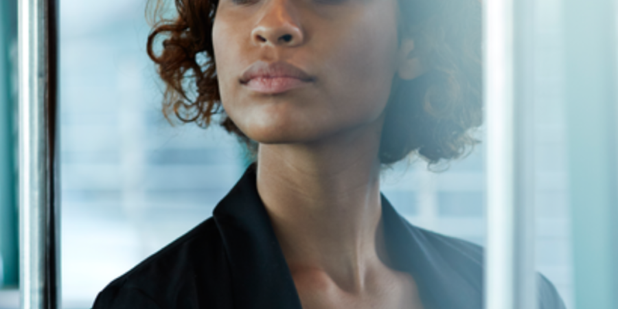 Woman on public transport, looking thoughtful.