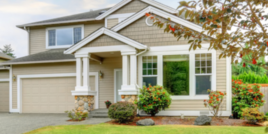 Two-story beige house with green lawn.