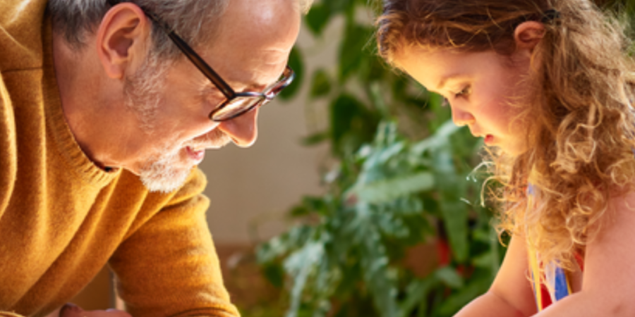 Grandfather and granddaughter playing with blocks.