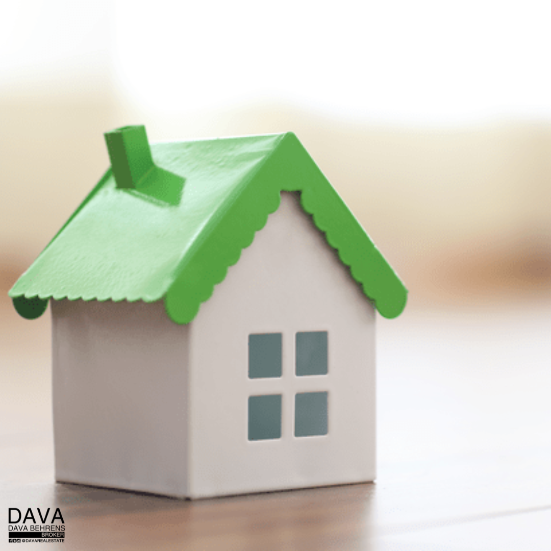 Green roofed model house on floor.