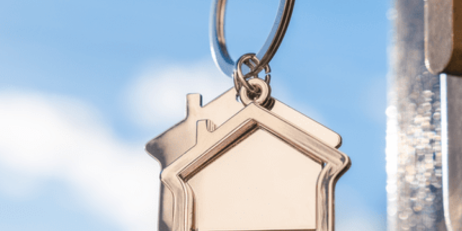 House key on keychain, blue sky.