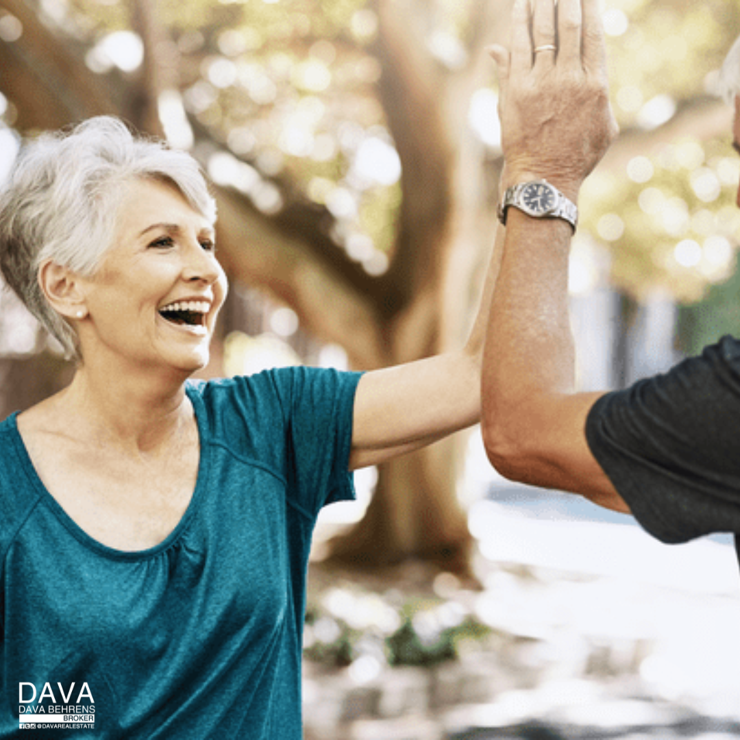 Happy senior couple high-five outdoors.