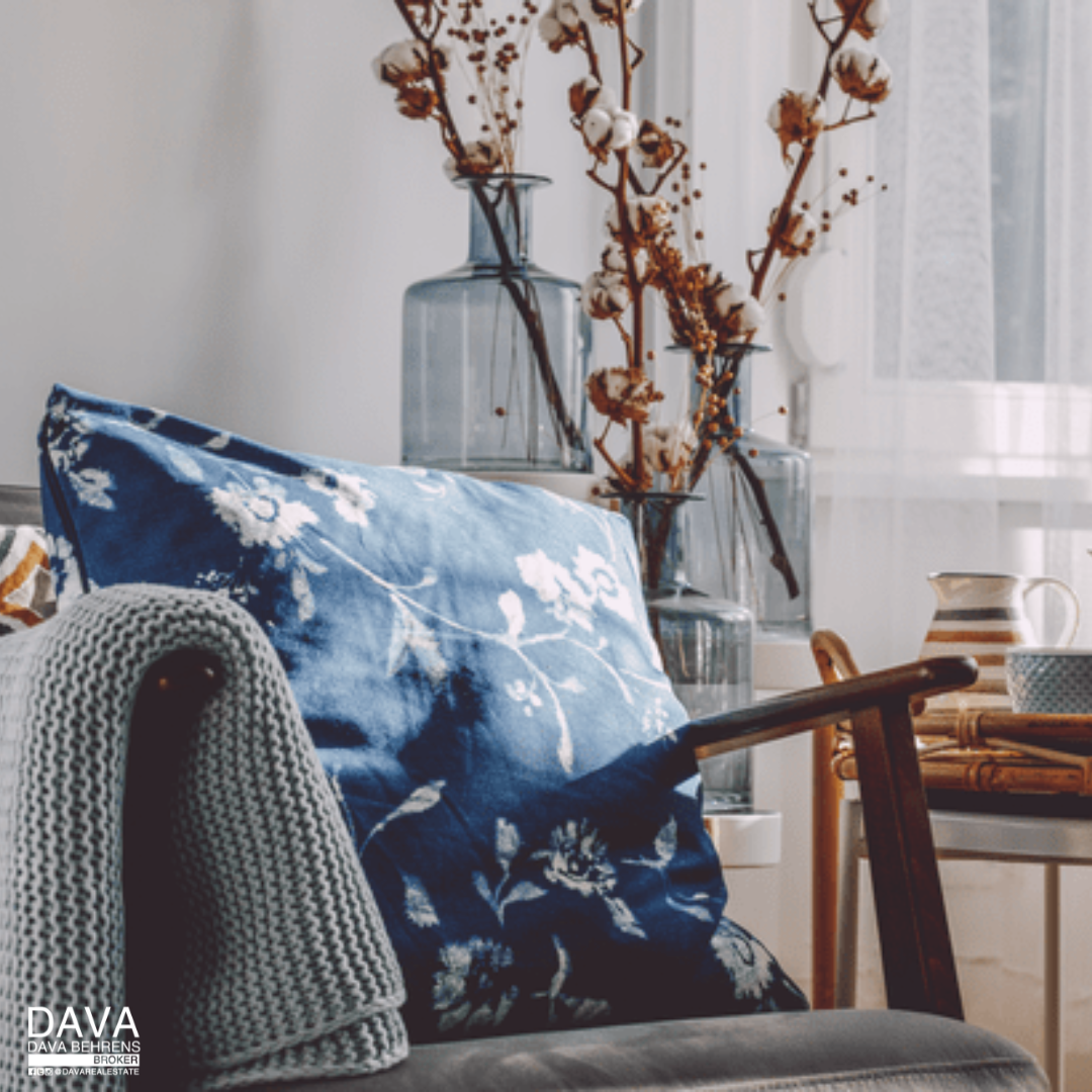 Blue floral pillow on cozy armchair.