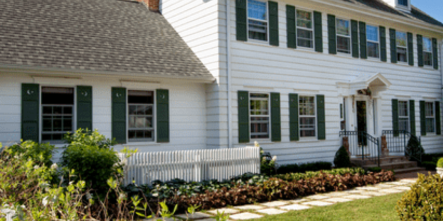 White colonial house with green shutters.