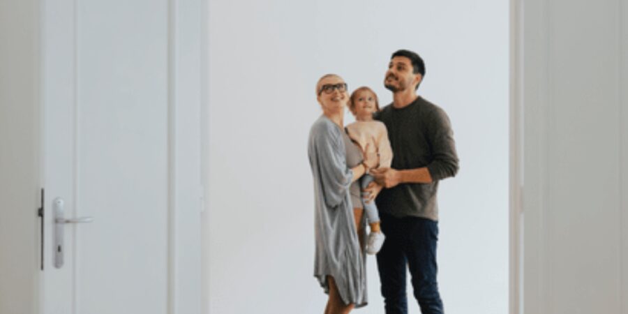 Family standing together in an empty room.