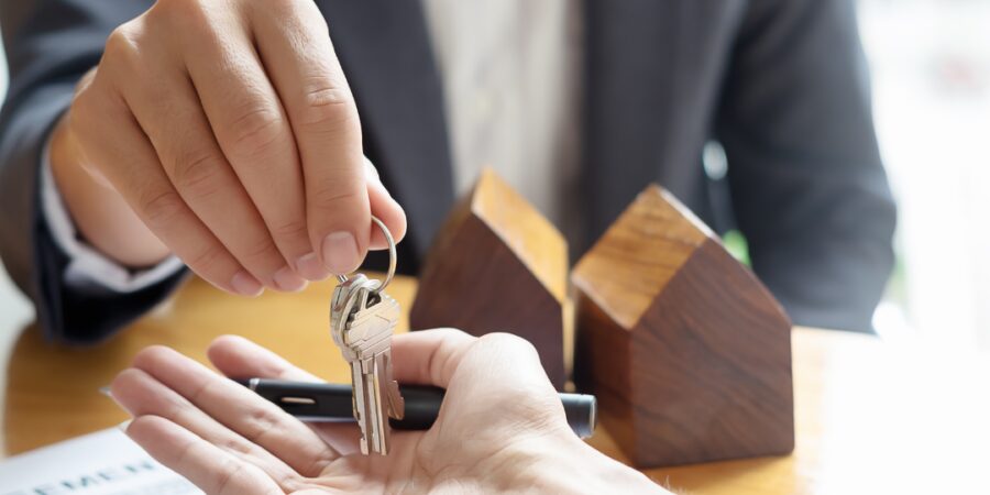 Person handing over keys in an office.