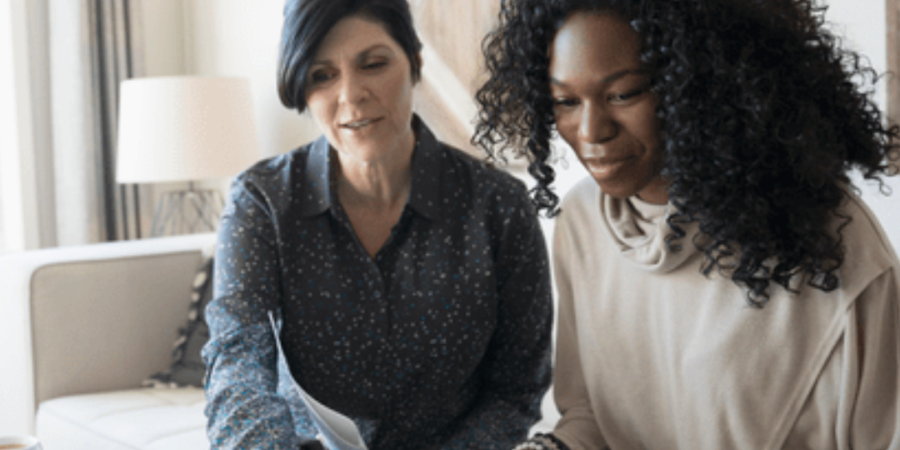 Two women reviewing documents together.