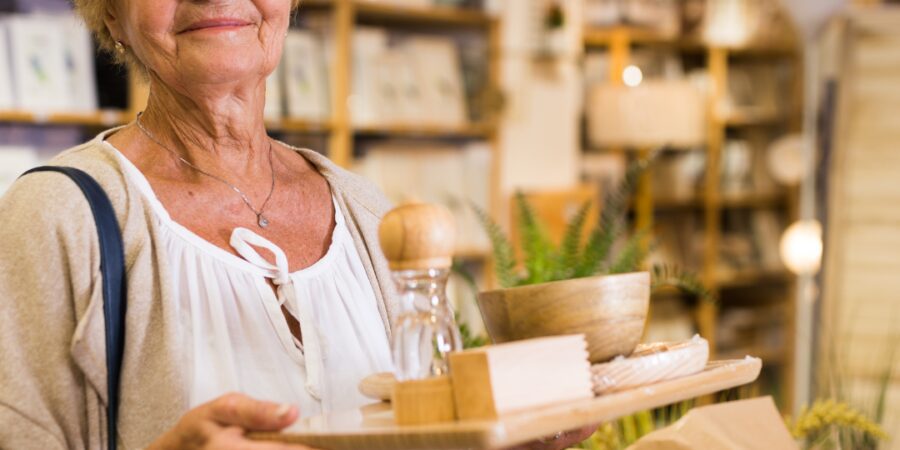 Senior woman holding a serving tray in store.