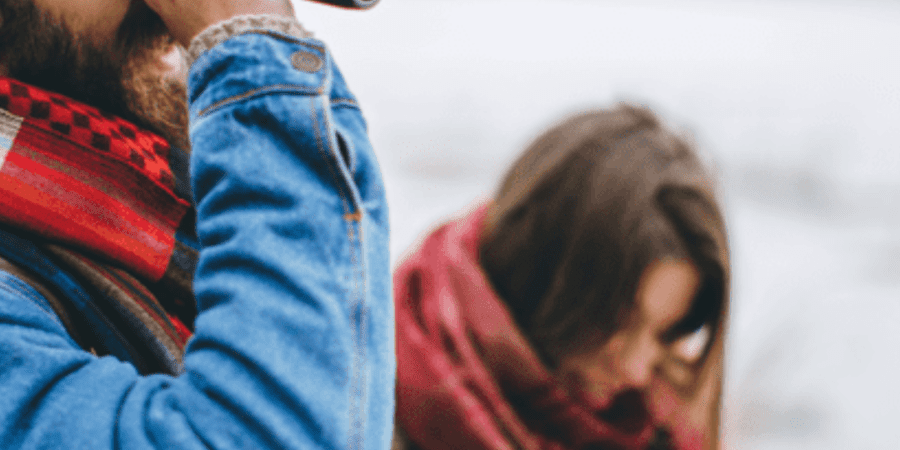 Man using binoculars by the sea.