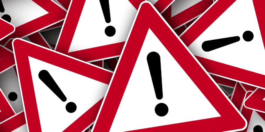 Pile of warning signs; urgent alert.