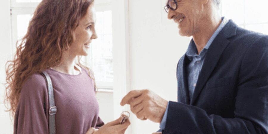 Woman receiving keys from real estate agent.