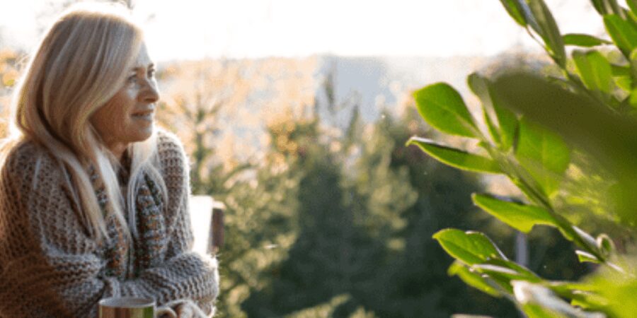 Woman enjoys coffee with scenic view.