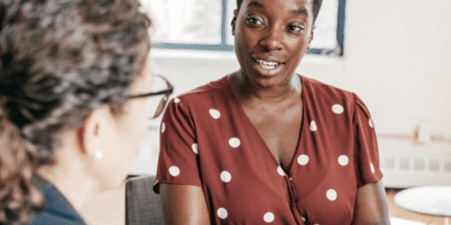 Woman in polka dot dress in meeting.