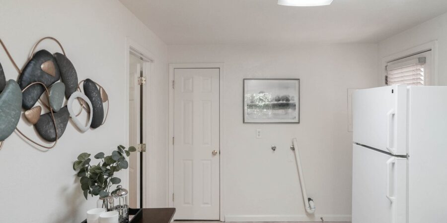 Minimalist kitchen with white refrigerator and decor.