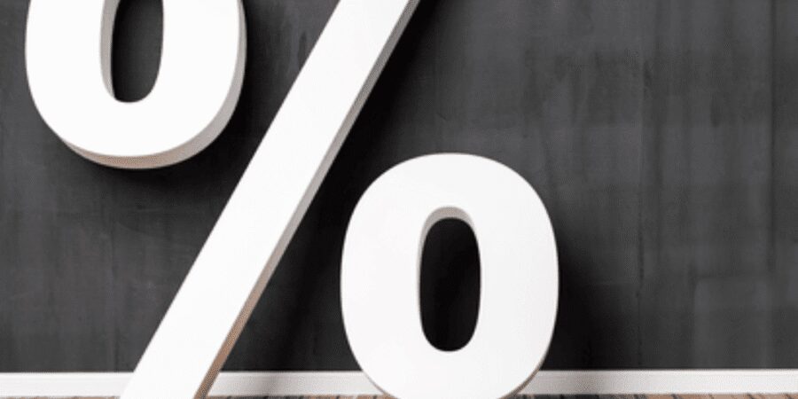 Percentage symbol on wooden floor background.