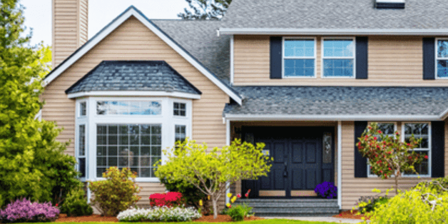Suburban house with manicured lawn and trees.