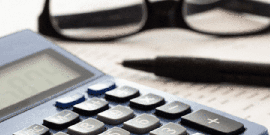 Calculator, glasses, and pen on paper.