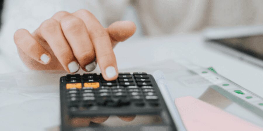Hand using calculator on a desk.