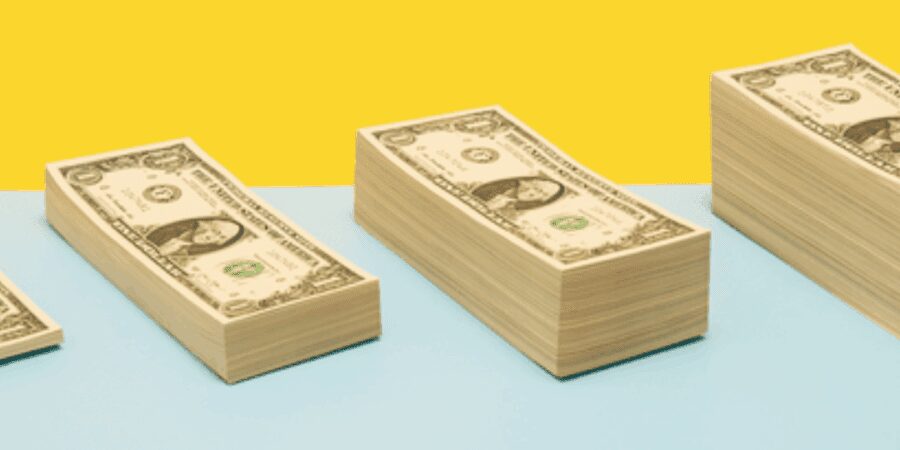 Stacks of dollar bills on colorful background.