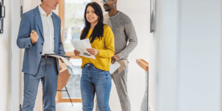 Three people discussing in a hallway.