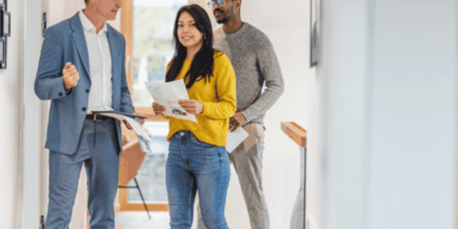 Three people discussing in a hallway.