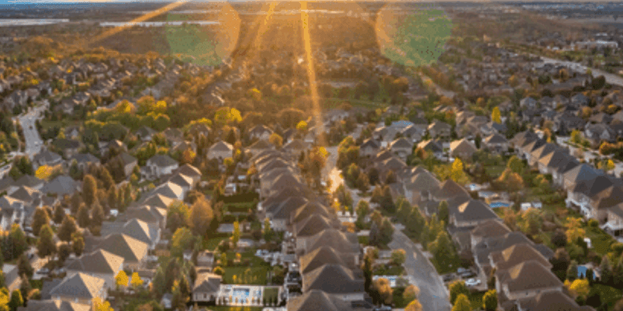 Suburban neighborhood at sunrise, aerial view.