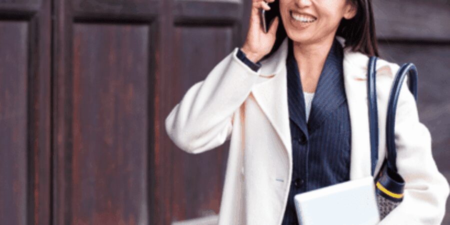 Smiling woman in business attire with laptop.