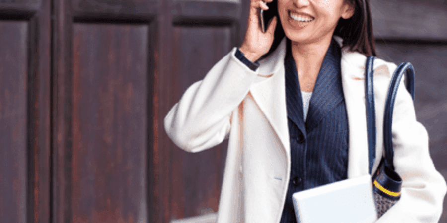 Smiling woman in business attire with laptop.