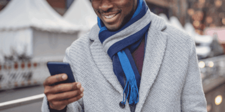 Man smiling while looking at smartphone.