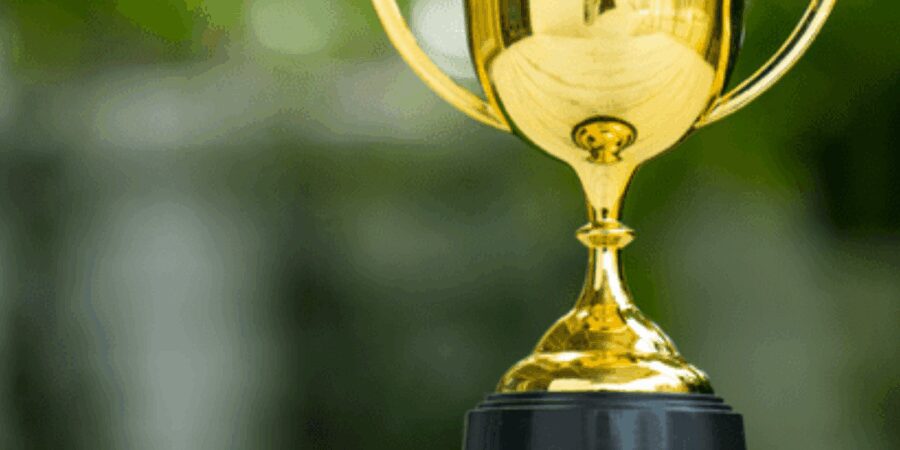 Golden trophy with a black base outdoors.