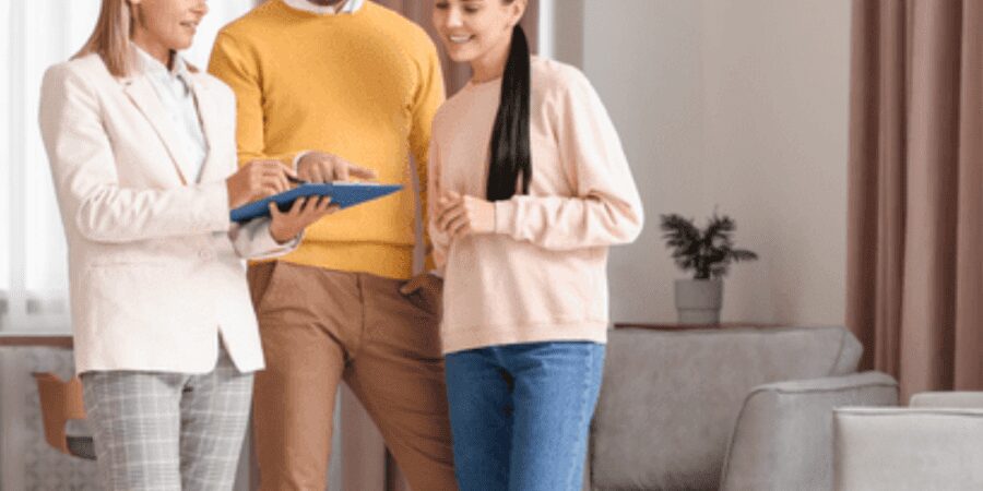 Three people reviewing documents in living room.